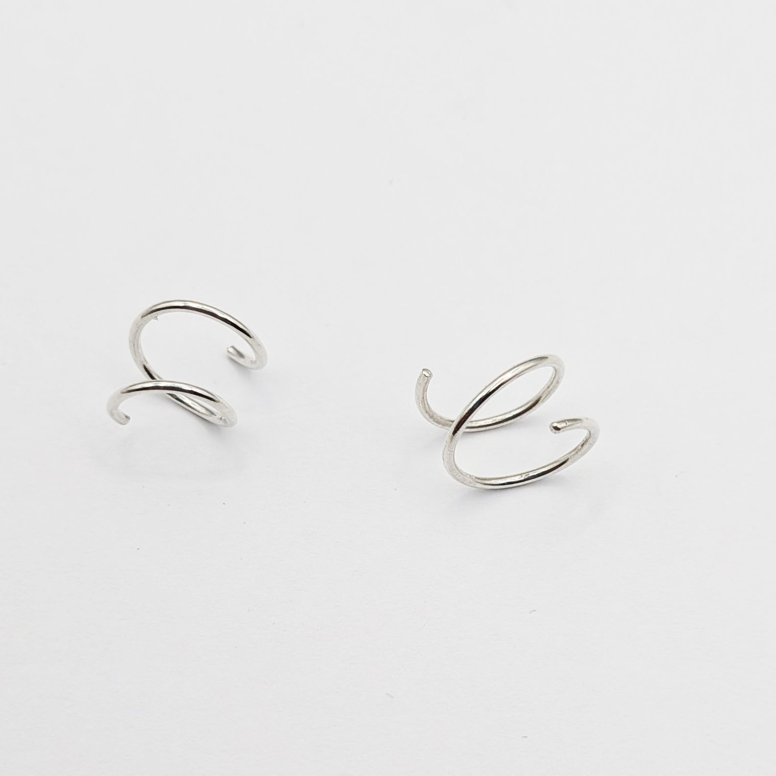 Silver wire earrings on a white background